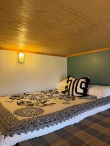 a bed in a room with a green wall at Self-contained studio by the beach in Paekakariki
