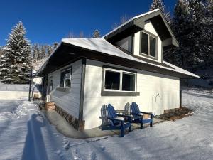 a small house with two chairs in the snow at Modern barn by the creek in Evergreen +9 photos