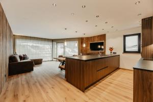 a kitchen and living room with a couch and a table at Dolomites Chalet Niuasi in Ortisei