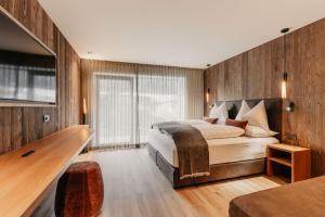a bedroom with a bed and a wooden wall at Dolomites Chalet Niuasi in Ortisei