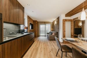 a kitchen and living room with a table and chairs at Dolomites Chalet Niuasi in Ortisei