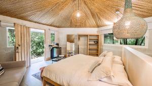 a bedroom with a bed and a couch at Norte Nosara - Steps to Playa Guiones in Nosara +69 photos
