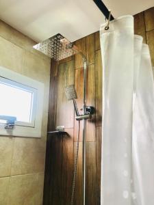 a shower in a bathroom with a window at Departamentos Los Robles 1 in Comodoro Rivadavia