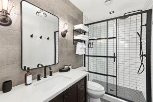 a bathroom with a sink and a toilet and a mirror at The Brick & Beam Boutique Hotel in Collingwood