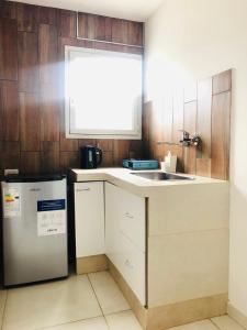 a kitchen with a sink and a refrigerator at Departamentos Los Robles 1 in Comodoro Rivadavia
