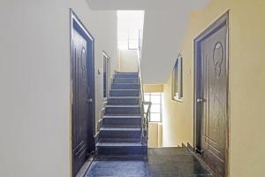 a hallway with a staircase with two sets of doors at Super Hotel O Honey Heights Near Botanical Garden in Kondapur
