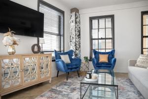 a living room with blue chairs and a tv at Angel City 1 bedroom Apartment in Los Angeles