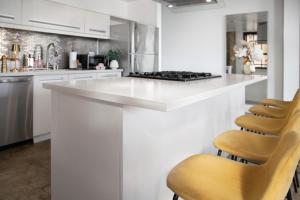 a white kitchen with a white counter and chairs at Bright lights central Downtown in Los Angeles