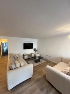 a living room with two couches and a flat screen tv at An Treth in Bude