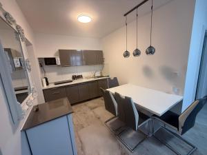 a kitchen with a white table and chairs at Wohung Leonard in Schwanenstadt