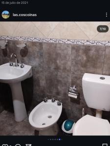 a bathroom with a white toilet and a sink at Cabañas Cosquín in Cosquín +43 photos