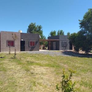a house with a large yard in front of it at Cabañas Cosquín in Cosquín
