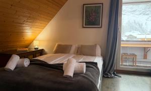 ein Schlafzimmer mit einem Bett in einem Zimmer mit Fenster in der Unterkunft Waterfall View in Kandersteg