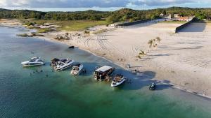 a group of boats in the water next to a beach at Lagoa do Bonfim RN in Natal