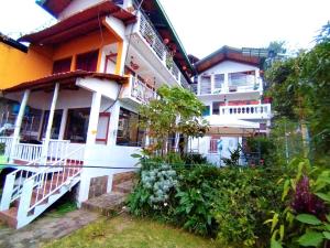 a white building with white balconies and plants at Hotel Victoria Atitlan in San Pedro La Laguna