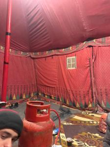 a man standing in front of a red tent at RUM LOREN lUXURY CAMP in Wadi Rum