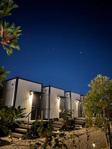 a row of metal containers at night with lights at NikkaHotel東郷店 in Togo