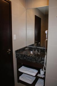 a bathroom with a sink and a mirror at Departamentos-Cabañas y Habitaciones Compartidas El Puente in El Calafate +21 photos