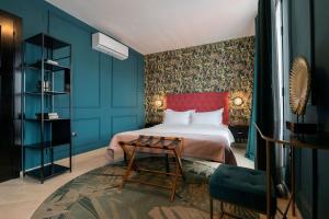 a bedroom with blue walls and a bed with a red headboard at Boutique Suites in Arcos de la Frontera