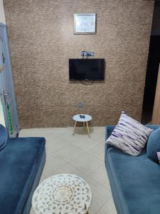 a living room with a couch and a tv on a brick wall at Tamazart ait melloul in Ait Melloul