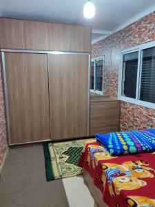 a bedroom with a bed and cabinets and a rug at Tamazart ait melloul in Ait Melloul