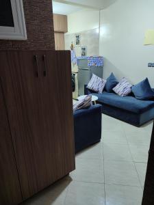 a living room with two blue couches and a cabinet at Tamazart ait melloul in Ait Melloul