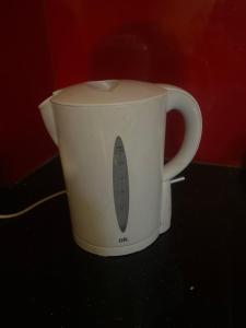 a white coffee pot with a utensil in it at Violet hotel 2 in Nha Trang