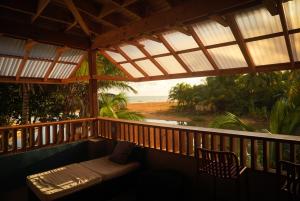 a porch with a couch and a view of the beach at Casa Coral in Luquillo