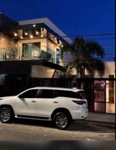 a white suv parked in front of a house at Flat Zona Sul in Teresina