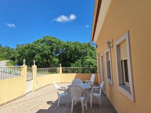 a patio with a table and chairs on a balcony at Casa do Pastana in Ancião