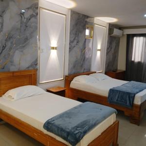 a hotel room with two beds and two lamps at Residence Annapurna Indian in Dakar