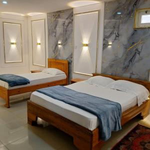 two beds in a room with two lamps on the wall at Residence Annapurna Indian in Dakar
