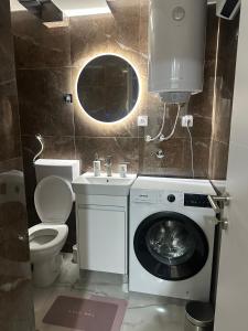 a bathroom with a washing machine and a sink at Arni apartments in Donja Vrežina +13 photos