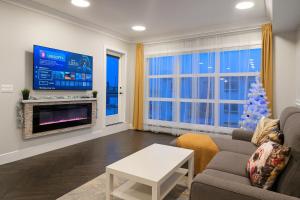 a living room with a television and a christmas tree at Family Stylish 1BR and Den Condo -Apartment with City View, Downtown, Balcony, Free Parking, In-Suite Laundry! in Calgary