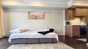 a large bed in a room with a kitchen at Family Stylish 1BR and Den Condo -Apartment with City View, Downtown, Balcony, Free Parking, In-Suite Laundry! in Calgary