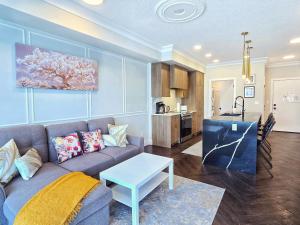 a living room with a couch and a table at Family Stylish 1BR and Den Condo -Apartment with City View, Downtown, Balcony, Free Parking, In-Suite Laundry! in Calgary