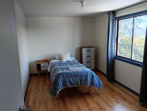 a bedroom with a bed and a window at Lomas de Hullinco Lodge in Petanesí Alto