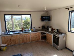a kitchen with a sink and a stove at Lomas de Hullinco Lodge in Petanesí Alto