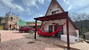 a house with a red hammock outside of it at VERONA Cabañas in Samaipata