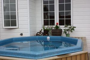 a blue pool sitting on a deck next to a house at Nupan Deluxe in Keflavík