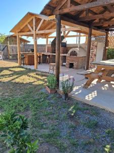 a pavilion with a picnic table and a pizza oven at Entre Espinos in Lo Chaparro