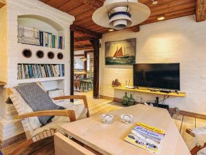 a living room with a table and a tv at 4 person holiday home in Asaa in Aså