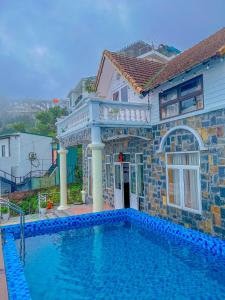 a house with a swimming pool in front of a house at Villa Đường Mây 2 in Tam Ðảo