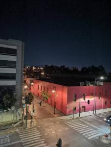 a building with pink lights on the side of it at Hostal Ciudad de México - Habitaciones privadas con Wi-Fi en el centro histórico in Mexico City