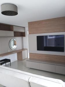 a living room with a large television on a wall at Sonatta in Torres