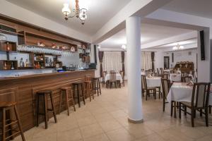 a restaurant with a bar and some tables and chairs at Pensiunea Restaurant Casa Lacului in Malaia