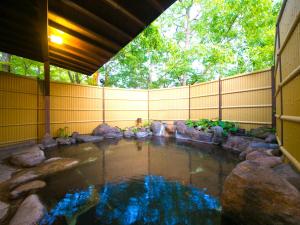 a koi pond in a backyard with a fence at Wa no Yado Sagiritei in Yufu