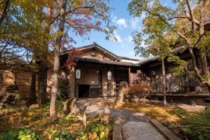 a japanese house with trees in front of it at Wa no Yado Sagiritei in Yufu