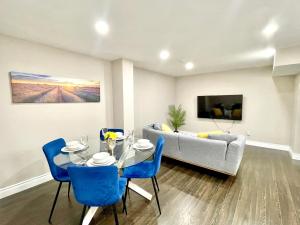 a living room with a table and blue chairs at Violet Escape Modern Apt 1B 1B, Kitchen, Parking in Richmond Hill
