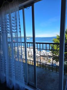 a room with a view of the ocean from a balcony at Hotel Bahia in Quellón